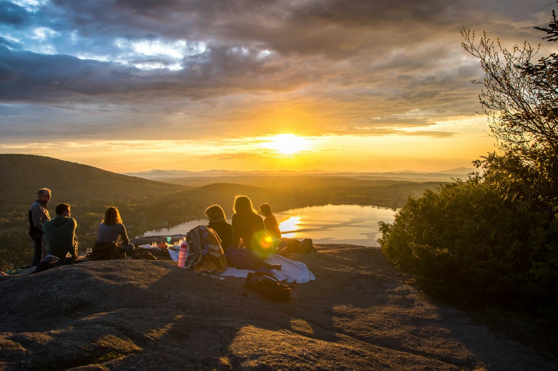 A group of friends gathered outdoors at sunset